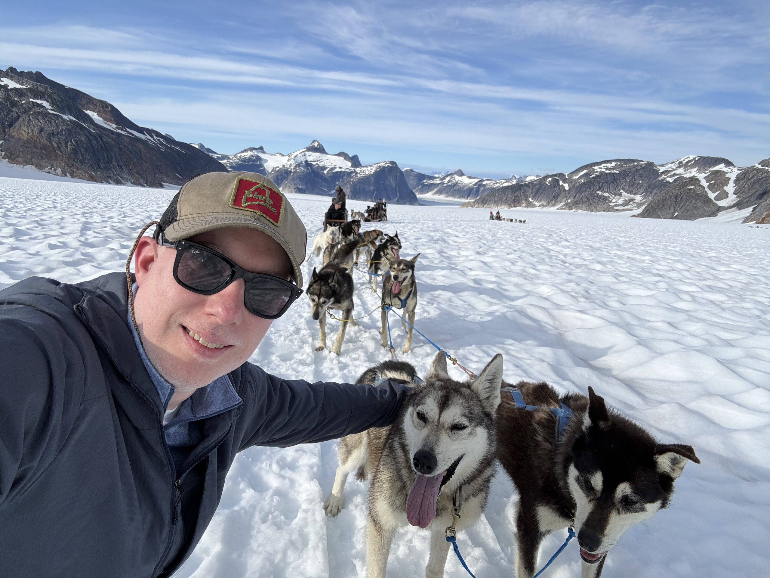 David Weliver posing with sled dogs in Alaska.